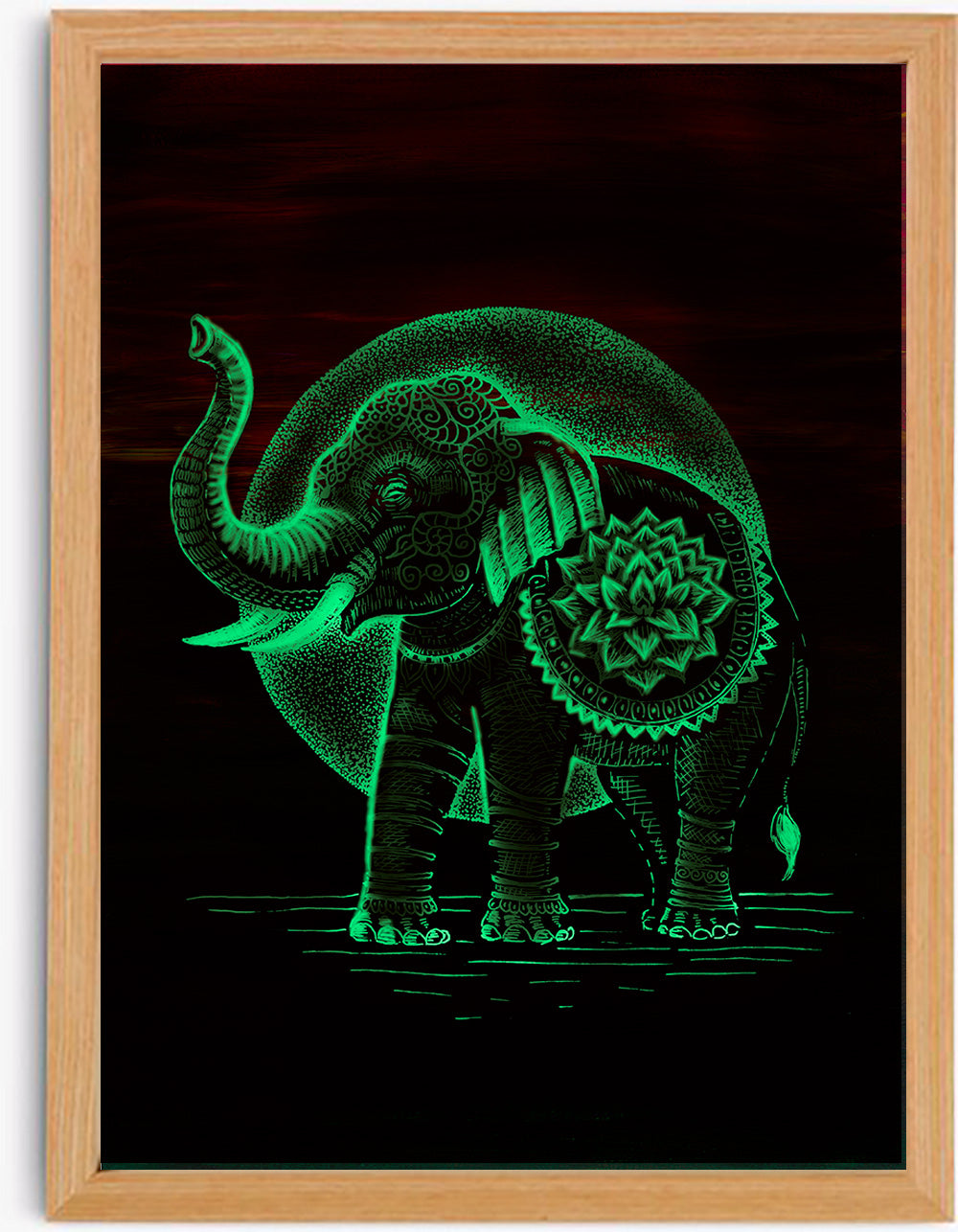 Svítící autorská ilustrace slona s mandalovým zdobením, která ve tmě září zeleným glow efektem, umístěná v přírodním dřevěném rámu.